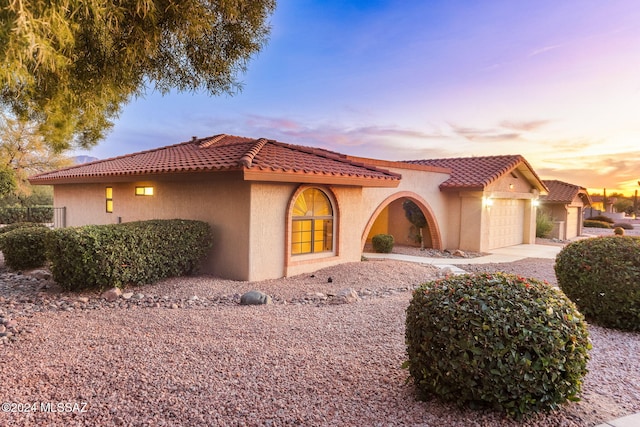 mediterranean / spanish-style house with a garage