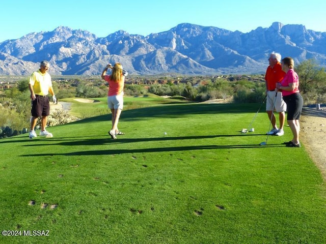 surrounding community with a mountain view and a lawn