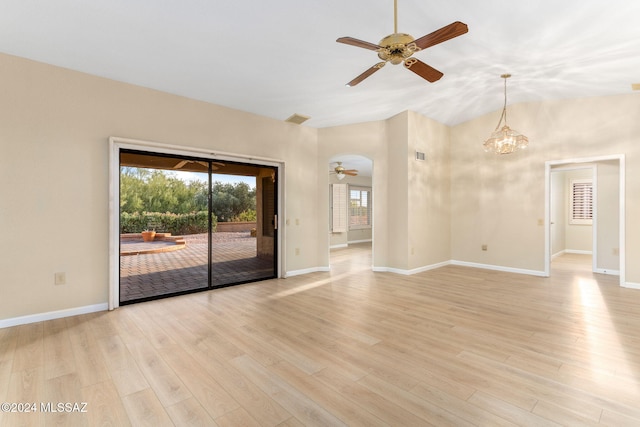 unfurnished living room featuring ceiling fan with notable chandelier, light hardwood / wood-style floors, and lofted ceiling