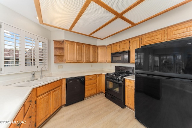 kitchen with sink, black appliances, and light hardwood / wood-style flooring