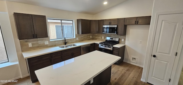 kitchen with tasteful backsplash, sink, a kitchen island, and stainless steel appliances