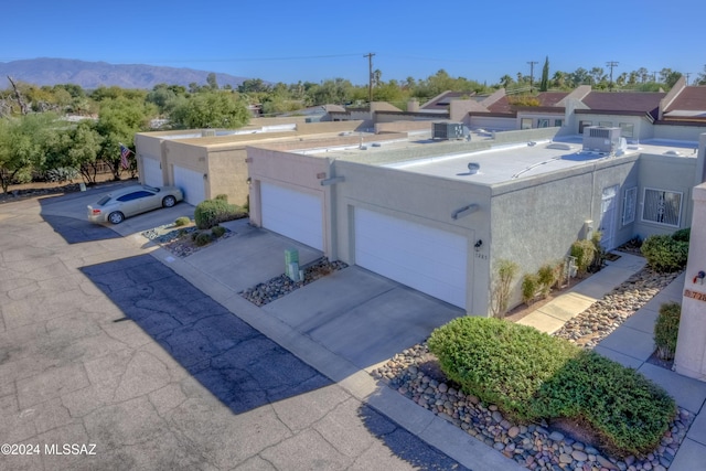 view of front of home featuring central AC, a mountain view, and a garage