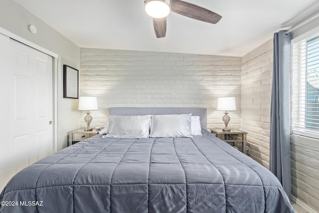 bedroom featuring multiple windows, ceiling fan, and a closet