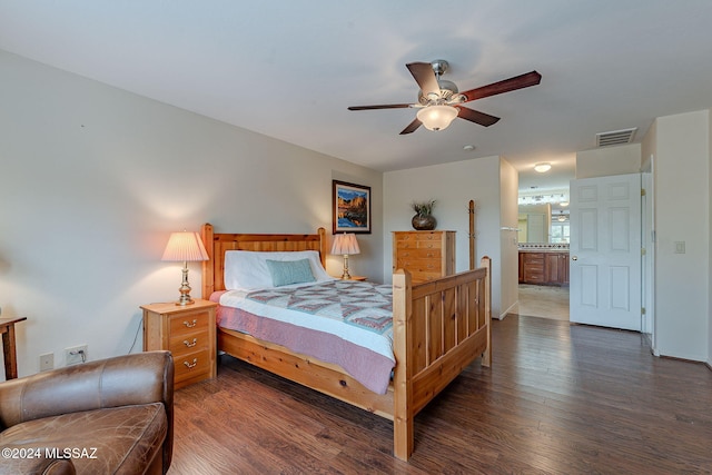 bedroom with ensuite bath, ceiling fan, and dark hardwood / wood-style floors