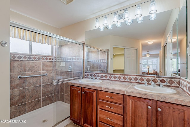 bathroom featuring tasteful backsplash, ceiling fan, vanity, and walk in shower