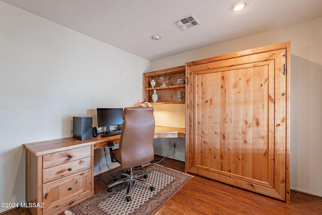 home office featuring built in desk and dark hardwood / wood-style floors