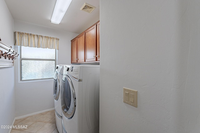 clothes washing area with washer and dryer and cabinets