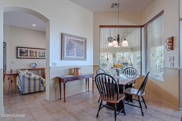 tiled dining area featuring a chandelier