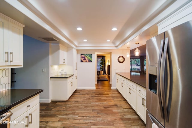 kitchen with white cabinets, appliances with stainless steel finishes, light wood-type flooring, and decorative light fixtures