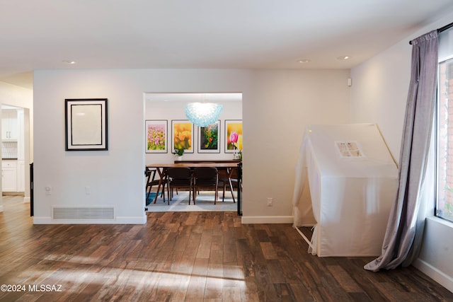 interior space with dark hardwood / wood-style floors, a wealth of natural light, and a notable chandelier