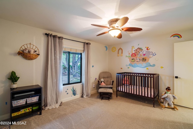 carpeted bedroom with a nursery area and ceiling fan