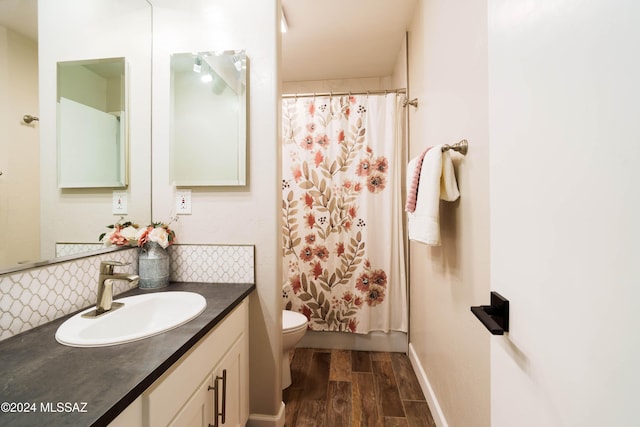 bathroom featuring decorative backsplash, vanity, hardwood / wood-style flooring, and toilet