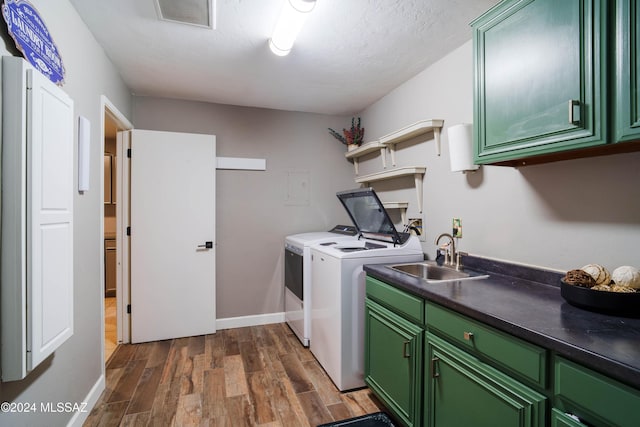 laundry area with cabinets, dark wood-type flooring, sink, separate washer and dryer, and a textured ceiling