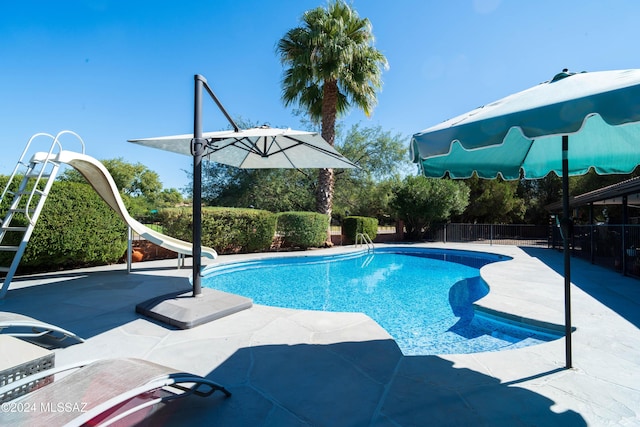 view of swimming pool with a patio area and a water slide