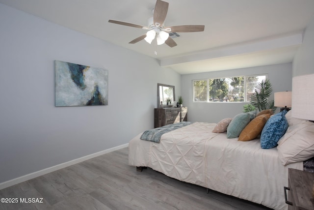 bedroom featuring hardwood / wood-style flooring, lofted ceiling with beams, and ceiling fan