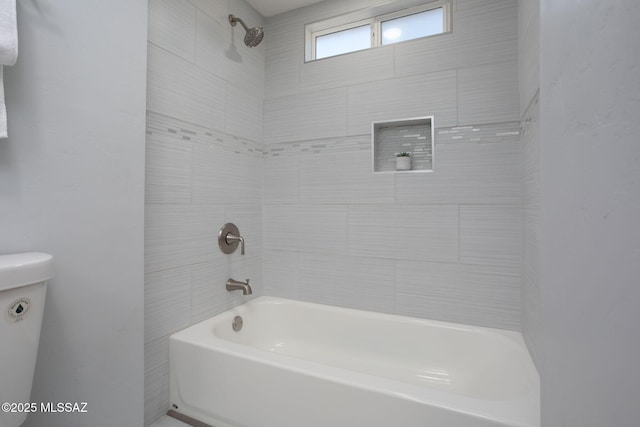 bathroom with tiled shower / bath and toilet