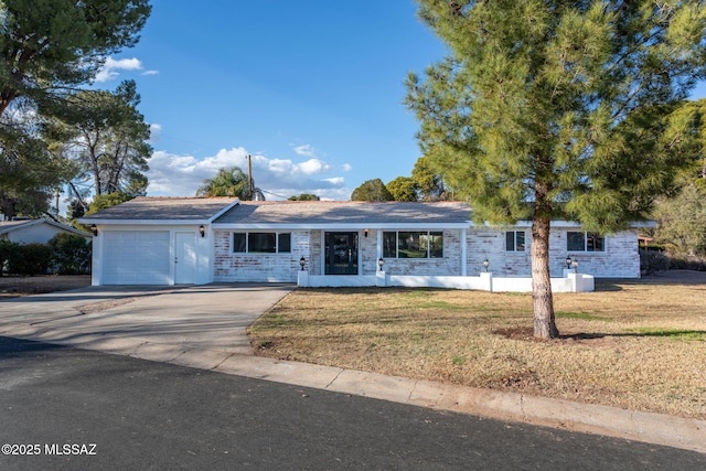 single story home with a front yard, concrete driveway, and an attached garage