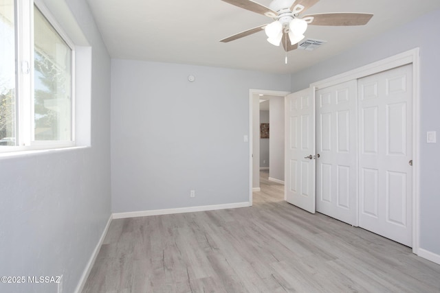 unfurnished bedroom with light hardwood / wood-style flooring, a closet, and ceiling fan