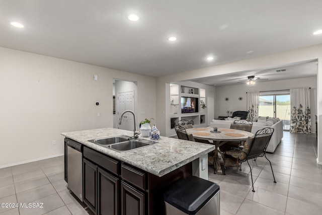 kitchen with a kitchen island with sink, sink, stainless steel dishwasher, ceiling fan, and light tile patterned floors