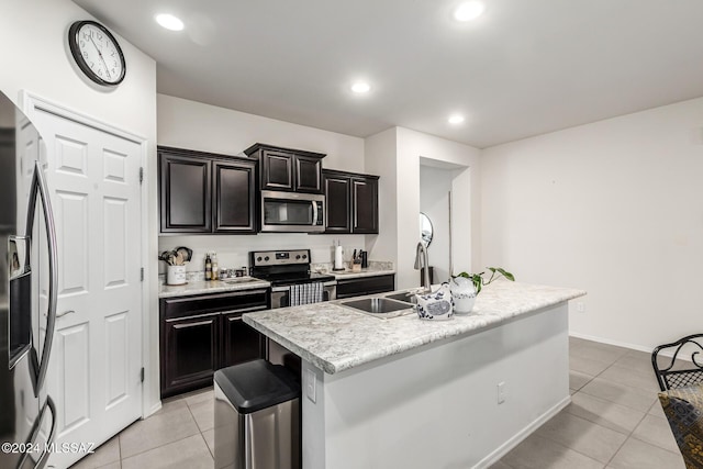 kitchen featuring a kitchen bar, appliances with stainless steel finishes, sink, an island with sink, and light tile patterned flooring