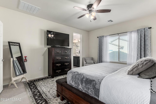 bedroom featuring light carpet, connected bathroom, and ceiling fan