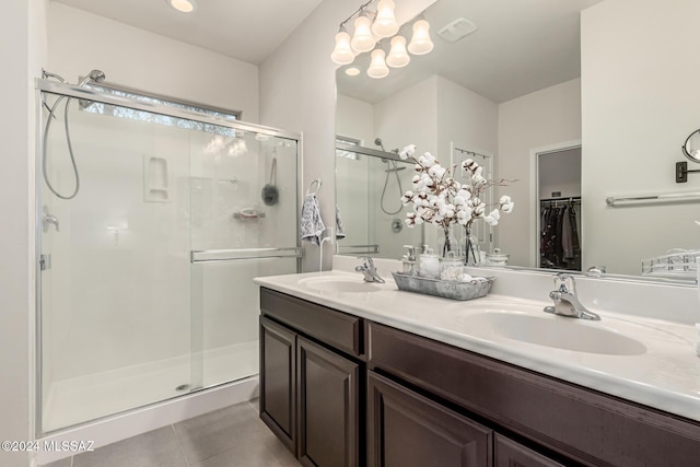 bathroom with tile patterned flooring, vanity, an inviting chandelier, and an enclosed shower