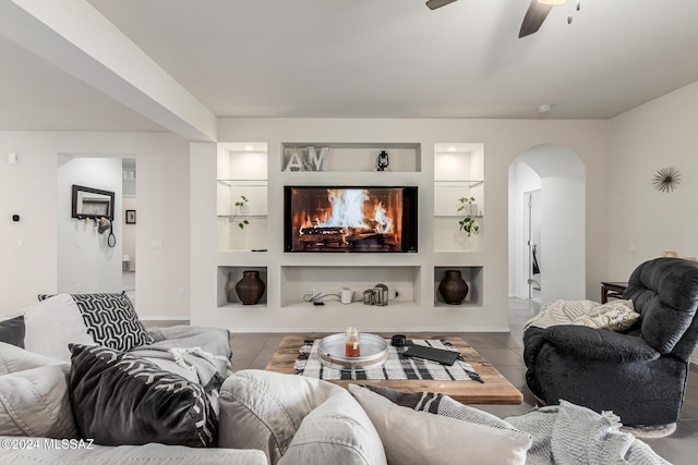 tiled living room with built in features and ceiling fan