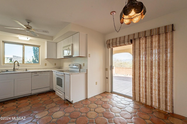 kitchen with ceiling fan, sink, decorative light fixtures, white appliances, and white cabinets