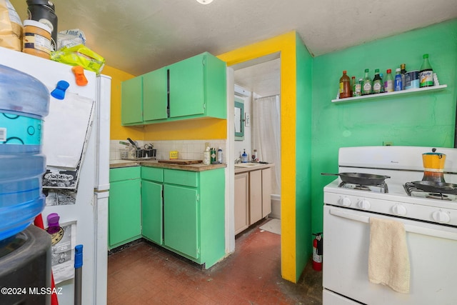 kitchen with white appliances, backsplash, and green cabinetry