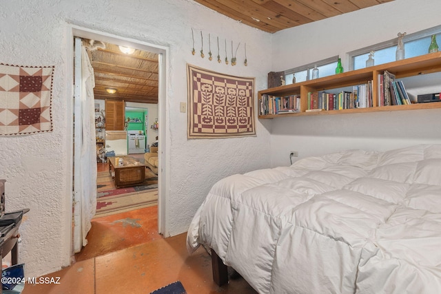 bedroom with wooden ceiling and concrete flooring