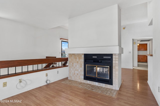 interior details with a tile fireplace and hardwood / wood-style floors