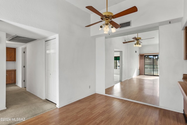 empty room with ceiling fan and light hardwood / wood-style floors