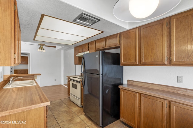 kitchen featuring ceiling fan, sink, white electric range, black refrigerator, and light tile patterned floors