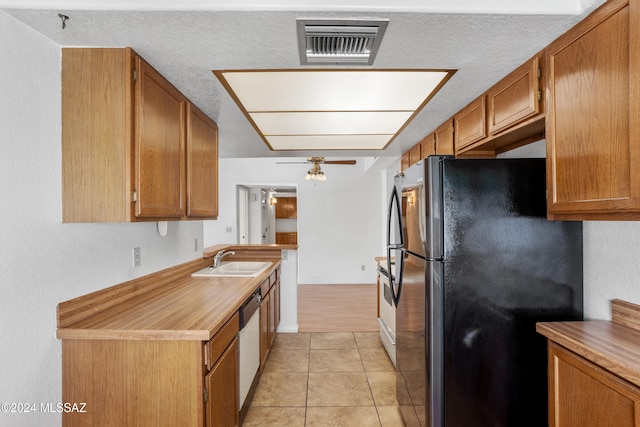 kitchen with a textured ceiling, stainless steel appliances, ceiling fan, sink, and light tile patterned flooring