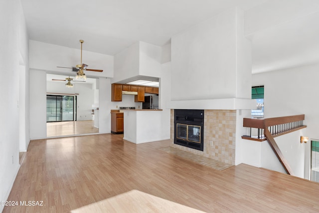 unfurnished living room featuring ceiling fan, a fireplace, and light hardwood / wood-style floors