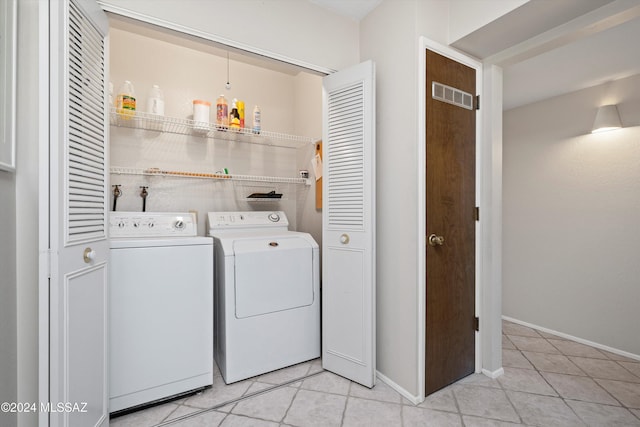 laundry area with washer and dryer and light tile patterned floors