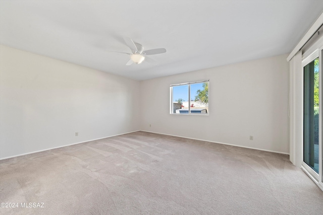 carpeted empty room with ceiling fan and a healthy amount of sunlight