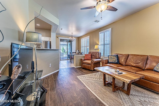 living room featuring ceiling fan with notable chandelier and dark hardwood / wood-style floors