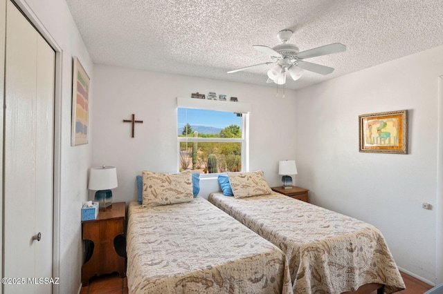 bedroom with ceiling fan, a textured ceiling, and a closet