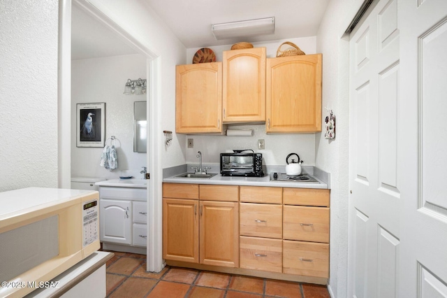 kitchen featuring light brown cabinetry, sink, and white appliances