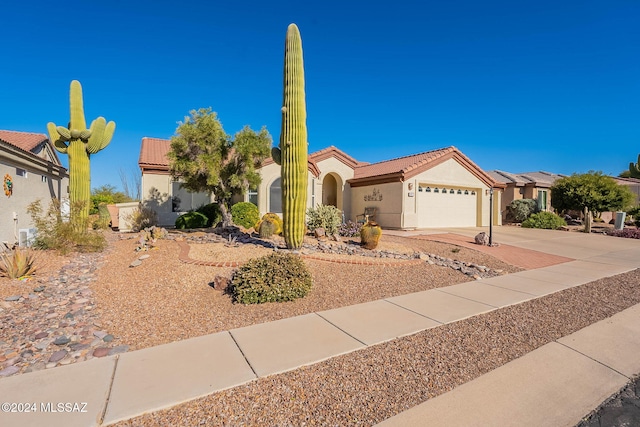 view of front of property with a garage, driveway, a tile roof, and stucco siding