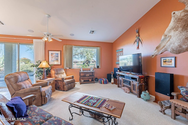 living area featuring carpet, visible vents, vaulted ceiling, and a ceiling fan