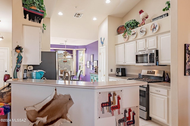 kitchen featuring stainless steel appliances, light countertops, visible vents, and white cabinetry