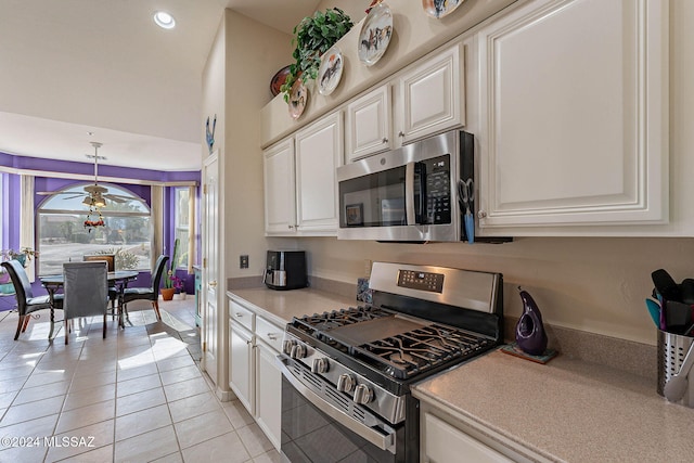 kitchen featuring light tile patterned floors, stainless steel appliances, light countertops, white cabinetry, and ceiling fan