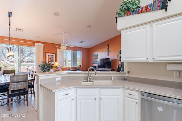 kitchen with light tile patterned floors, light countertops, stainless steel dishwasher, a sink, and a peninsula