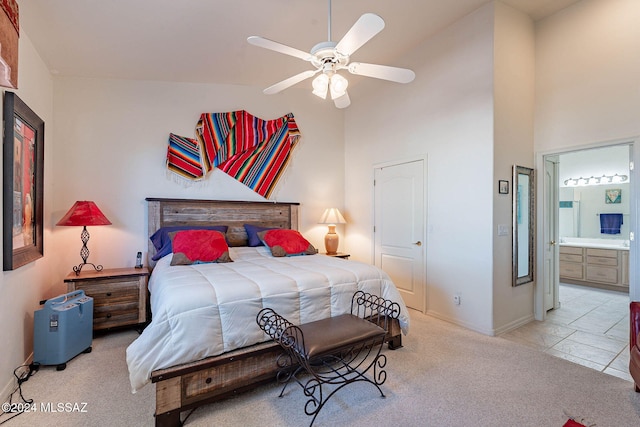 bedroom featuring carpet, a ceiling fan, ensuite bath, high vaulted ceiling, and baseboards