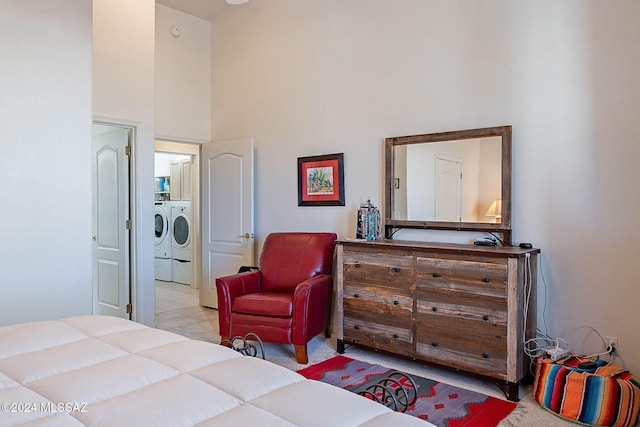 bedroom featuring a high ceiling and washer and dryer