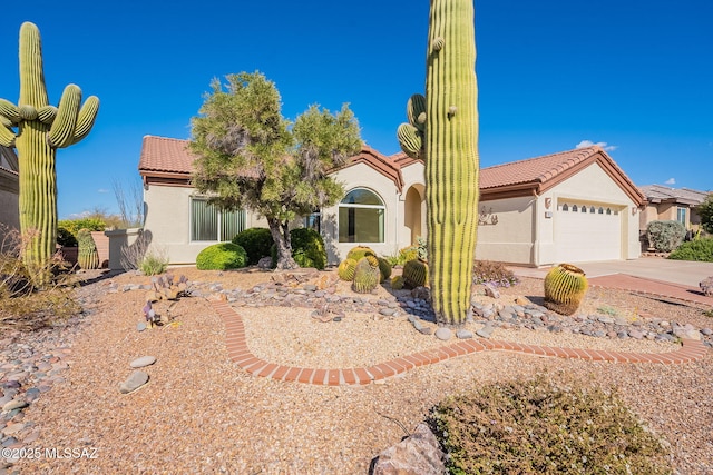 view of front of home with driveway, an attached garage, a tile roof, and stucco siding