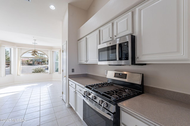 kitchen with appliances with stainless steel finishes, light tile patterned flooring, white cabinetry, and recessed lighting