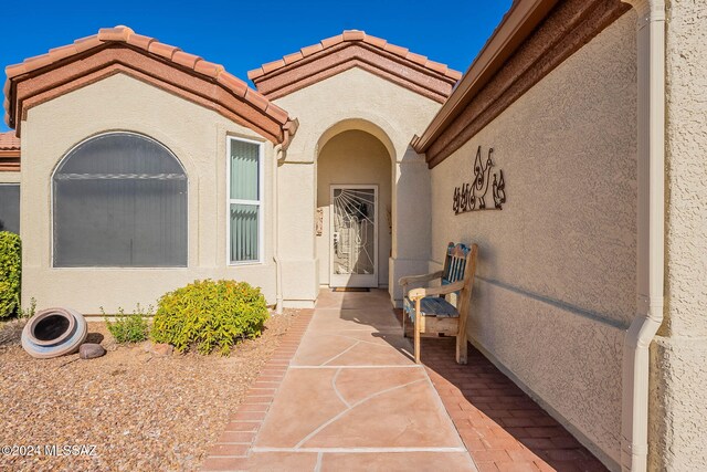 entrance to property featuring stucco siding and a tiled roof